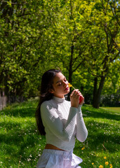 Fototapeta premium Woman with dark hair enjoying a sunny day of spring in a public park