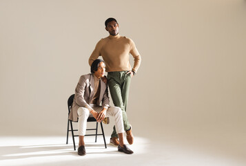 Stylish men posing confidently in modern fashion studio, showcasing elegant attire