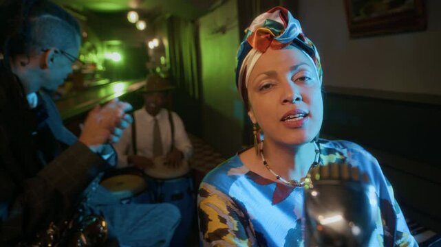 Slowmo of vibrant jazz trio lighting up room with Biracial female vocalist singing emotionally at camera, saxophonist clapping along, and percussionist setting beat in cozy, neon-lit bar