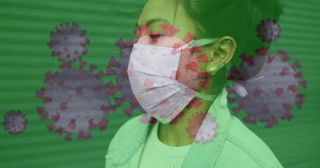 Asian woman wearing mask, virus graphics overlay, focusing on health safety
