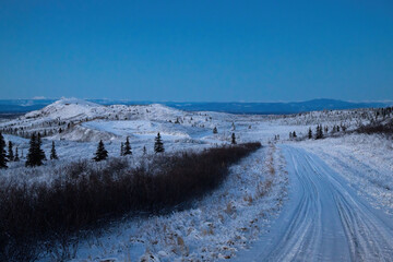 Snowy road and hills on winter day in Alaska