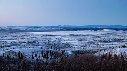 Snowy field with icy lake in Alaska