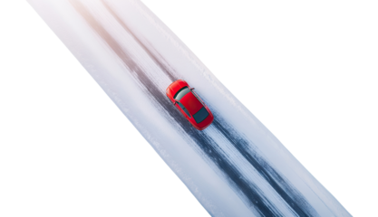 Red car on a snow-covered road, isolated on transparent cutout background