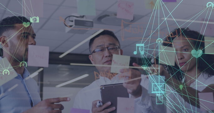 Image of network of connected media icons with business people brainstorming at a meeting