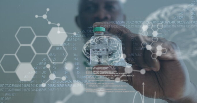 Medical data processing against male doctor wearing face mask holding covid 19 vaccine