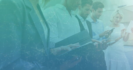 Image of network of connections over business people using electronic devices