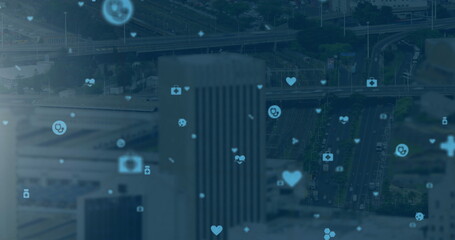 Image of digital icons over cityscape on blue background