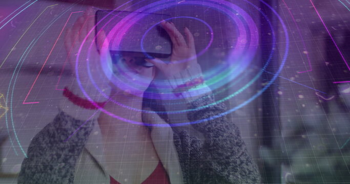 Light trails over neon scope scanner against caucasian woman gesturing while wearing vr headset