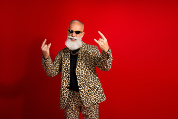 Fashion model man in leopard print suit with iconic gestures on vibrant red background exuding style and confident energy