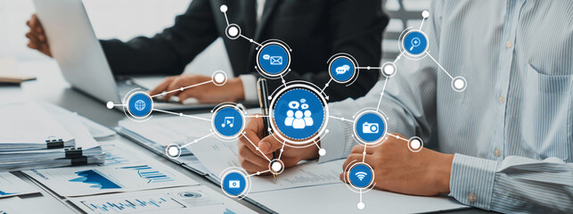 Professionals engage in a collaborative effort utilizing media technology for innovative communication strategies in a contemporary office environment. Amity