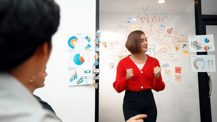 Fototapeta premium Young beautiful caucasian businesswoman presenting marketing strategy by using mind map, graph while answering questions with confident. Teamwork, brainstorming, discussing concept. Immaculate.