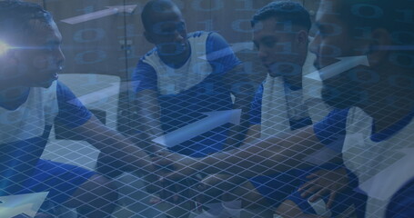 Image of arrows and binary coding over football players stacking hands in changing rooms
