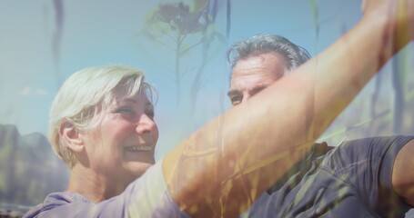 Image of glowing light over smiling senior couple dancing outdoors © vectorfusionart