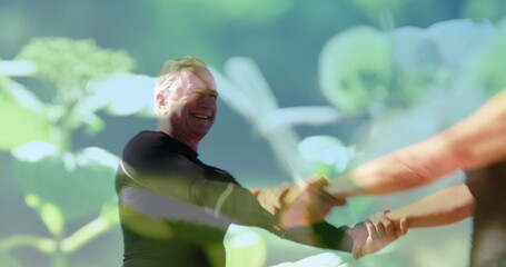 Image of glowing light over smiling senior couple dancing over plants © vectorfusionart
