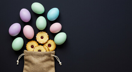 Painted Easter Eggs, Easter eggs and cookies in a burlap sack on a dark background