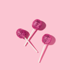 Disco pink sugar lollipops, creative candy layout, retro nostalgia.