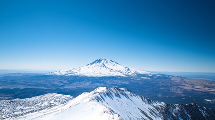 A breathtaking view of a snowy mountain peak surrounded by clear blue skies