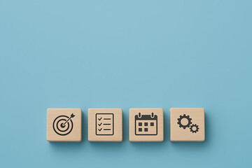 strategic planning and productivity concept with wooden blocks featuring target checklist calendar and gear icons on blue background ideal for business workflow management or goal setting visuals