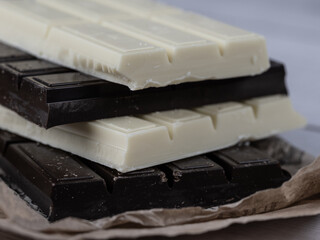 Close-up of stacked white and dark chocolate bars