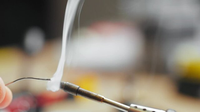 A Heated Soldering Iron Tip Coated with Rosin for Solder, Emitting Smoke.