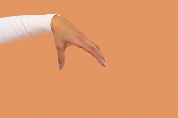 Hand reaching out against  warm orange background as part of  creative visual expression about...
