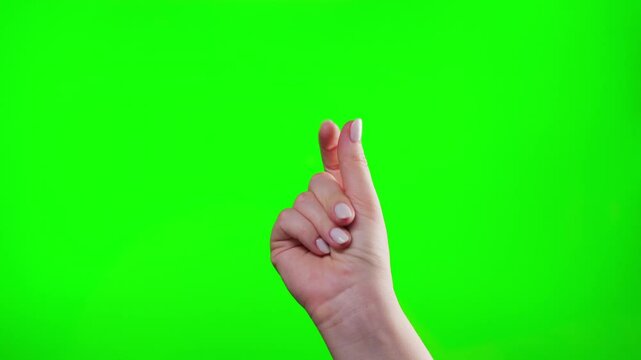Close-up of hand snapping finger making hand gesture isolated on green chroma key background. High quality 4k footage