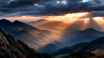 Obraz premium Golden rays of sunlight filter through the clouds, casting a soft, golden light over the majestic mountains and valleys below.