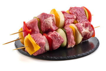 Raw meat skewers with vegetables isolated on white background.