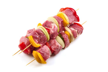 Raw meat skewers with vegetables isolated on white background.
