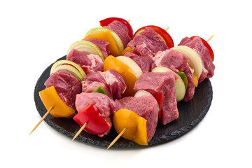 Raw meat skewers with vegetables isolated on white background.