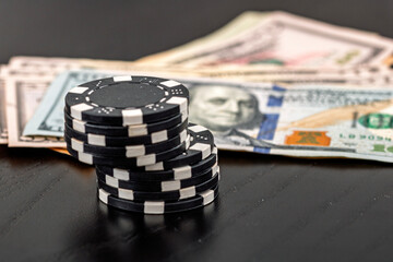 Stacks of poker chips with money on black background