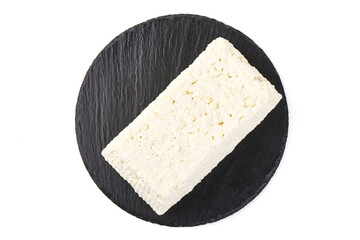 Fresh cottage cheese with lettuce on black slate plate, isolated on white background.