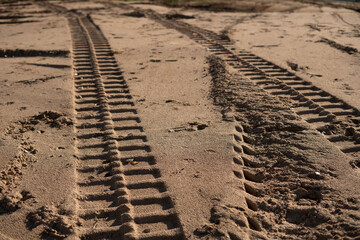 photo Detailed View of Vehicle Tire Tracks Imprinted on Sandy Terrain Showcasing Outdoor Adventure,...