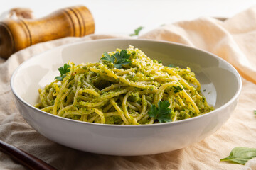 Vegetarian vegan green pasta, Spaghetti pasta with broccoli pesto sauce and vegan cheese in white plate.Healthy food.