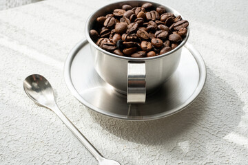 coffee beans in metal cup on white background