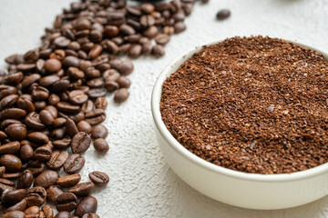 coffee beans, a cup of espresso and ground coffee on brown background