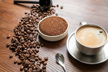 coffee beans, a cup of espresso and ground coffee on brown background