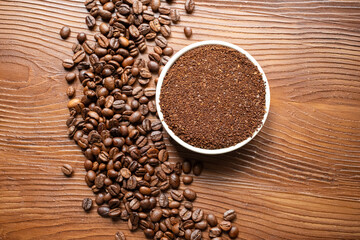 coffee beans, a cup of espresso and ground coffee on brown background