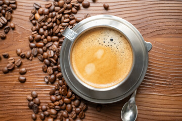 coffee beans, a cup of espresso and ground coffee on wooden background