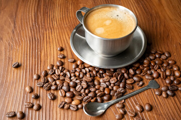 coffee beans, a cup of espresso and ground coffee on brown background