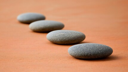 Row of Smooth Gray Stones on Orange Surface Close Up