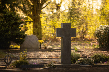 Friedhof. Ein großes Kreuz aus Stein.