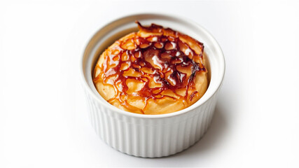 Caramelized Dessert ? A creamy dessert in a white ramekin with a golden-brown, crispy top. Its rich texture is highlighted against a clean white background.