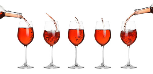 Wine splashing in glasses on white background