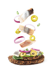Tasty bruschetta with herring and flying ingredients on white background