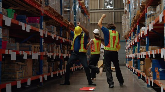 Warehouse workers are dancing happily after a successful job.