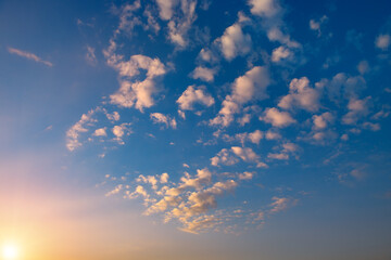 Sunset with bright sun, blue sky and pink clouds