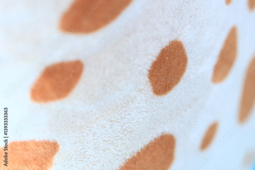 Poster Close-up view of a giraffe's distinctive spotted pattern on a soft blanket