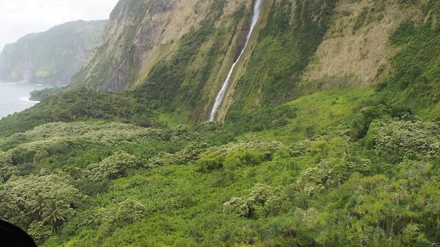 Helikopterflug &uuml;ber Big Island zum Wasserfall mit Landung &ndash; Blick auf Mauna Loa, Lavafluss ins Meer, Mauna Kea im Hintergrund, atemberaubende Natur, Wolken, Felsen, tropisches Paradies