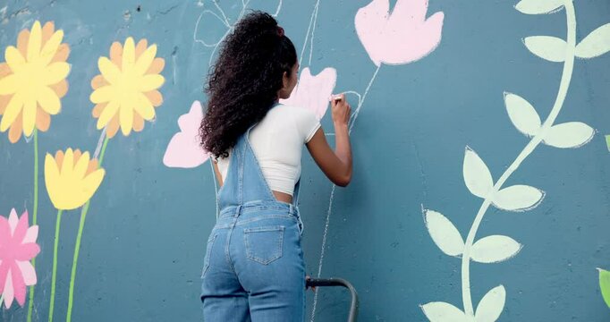 Art, woman and painting on wall with ladder for creative design, flower decor and volunteer. Artist, girl and painter outdoor with brush for community mural, floral color and back for charity project